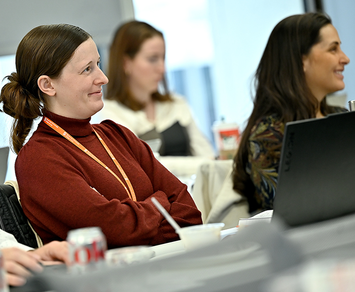 Four students sit at their desks and smile at the speaker during the Voting Rights residency in DC