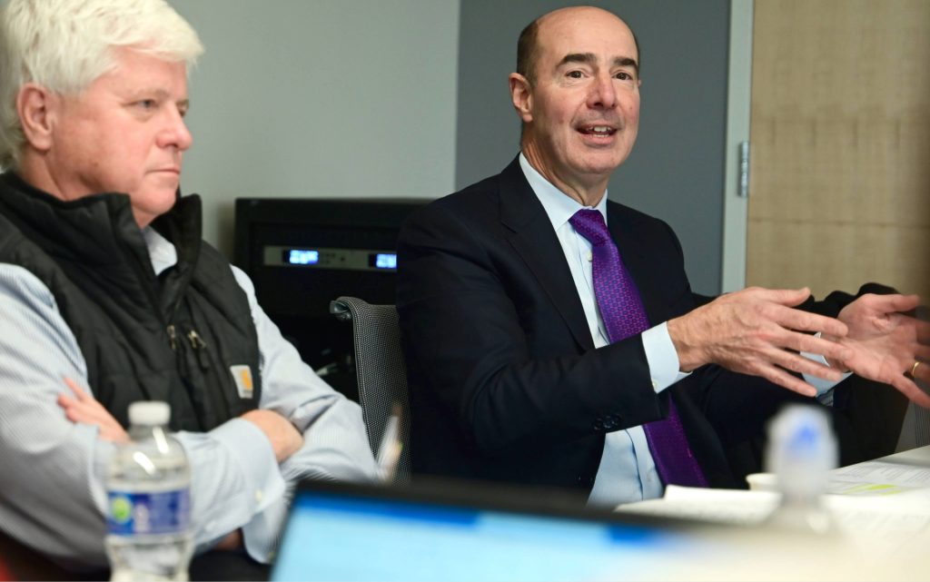 Gene Scalia sitting at table speaking in class with Hon. Randel Johnson. 