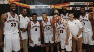 Kevin Belbey ’13, G’16, L’16 standing with basketball players on Boeheims Army. 