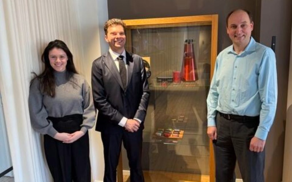 Austin Dewey and another extern and a supervisor standing together in a building. 