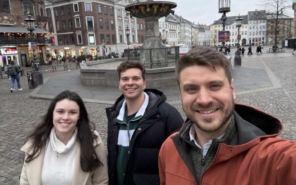 Austin Dewey with 2 other people standing in front of statue in Copenhagen
