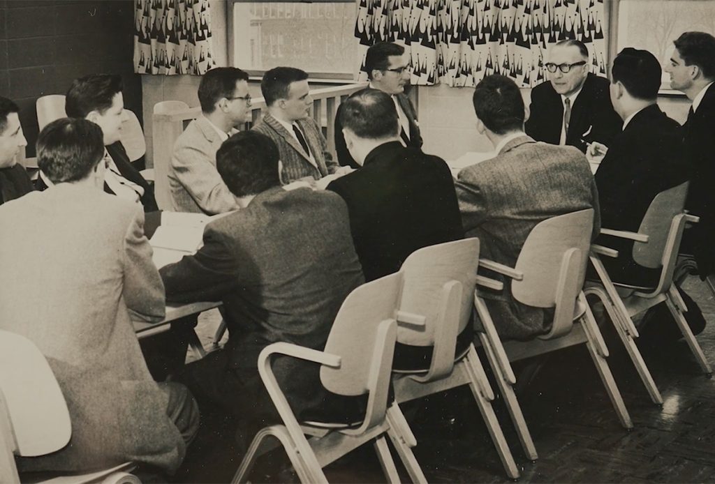 Men sitting around a table in a Syracuse Law classroom in the 1950's.