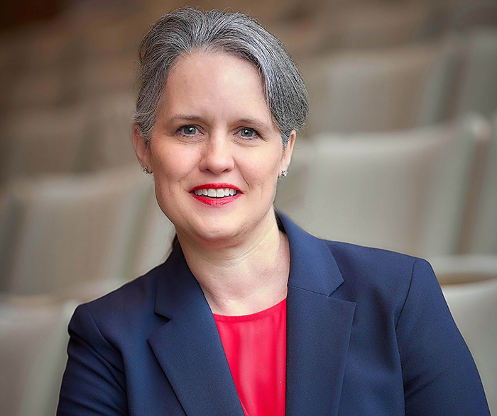 A woman in a blue blazer and red blouse.