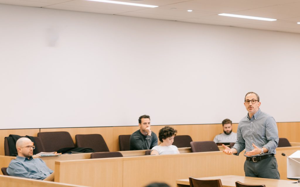 Creager listens in the classroom to Professor Berger lecture during the January 2023 residency