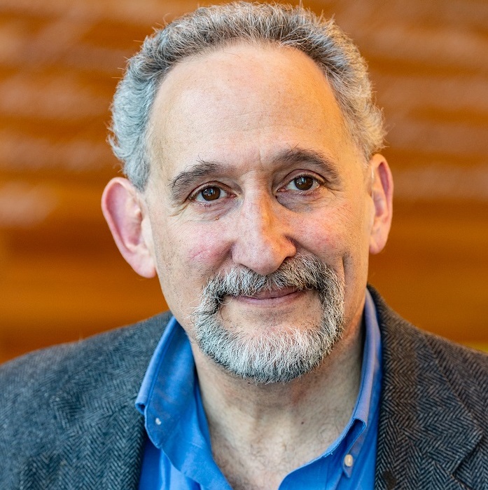 A middle-aged white man in a blue shirt and dark jacket