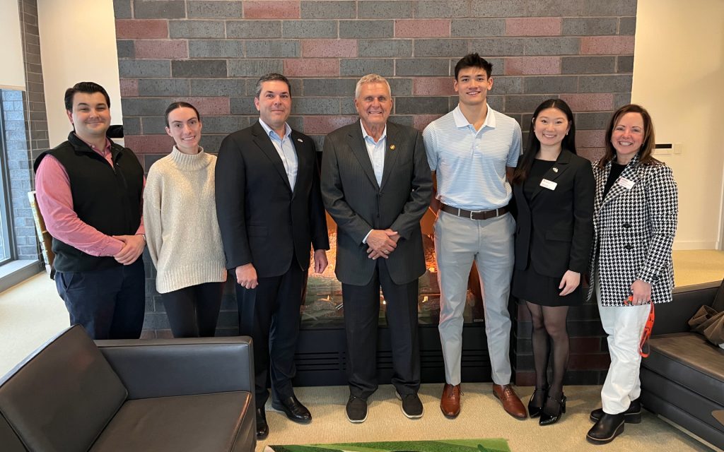 Pictured from left to right Anthony Ruscitto L'27, Hannah Rice L'27, Mike Marino L’96, Michael Marino L’ 74, Matt Cohn L'28, Rebecca Lee L'27, and Beth Kubala In front of fireplace in Dineen Hall.
