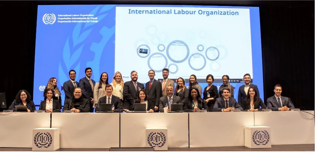 Residency group at the International Labor Organization in Switzerland in front of a desk and large screen