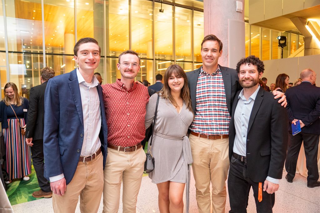 Alumni pose for a photo in the Dineen Hall atrium during the after-party.