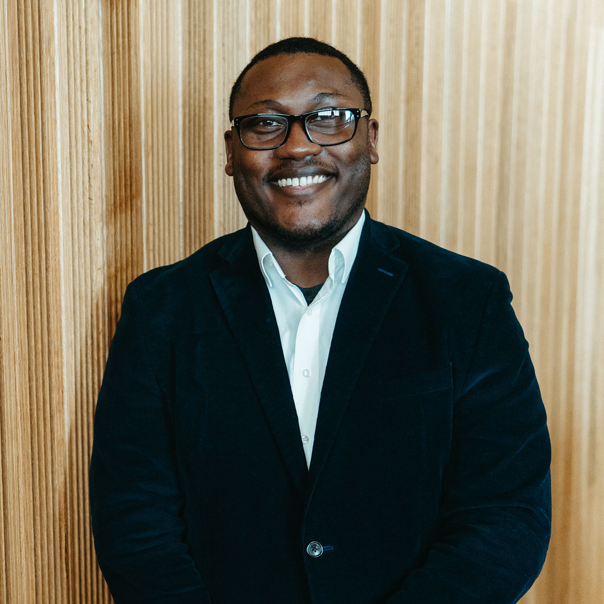 Nate Linton headshot in front of a wood background