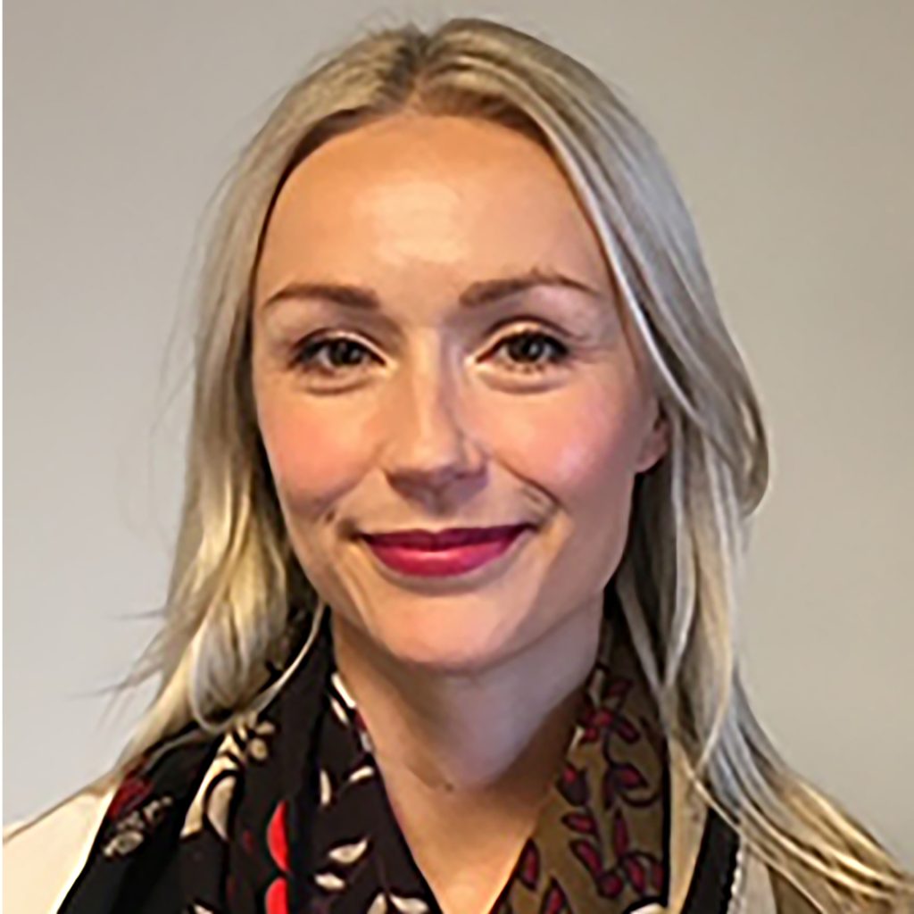 Headshot of Lotta Lampela in front of a gray wall