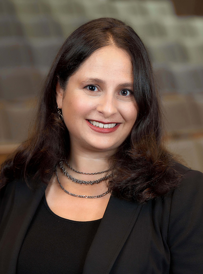 A woman in a black suit and blouse.