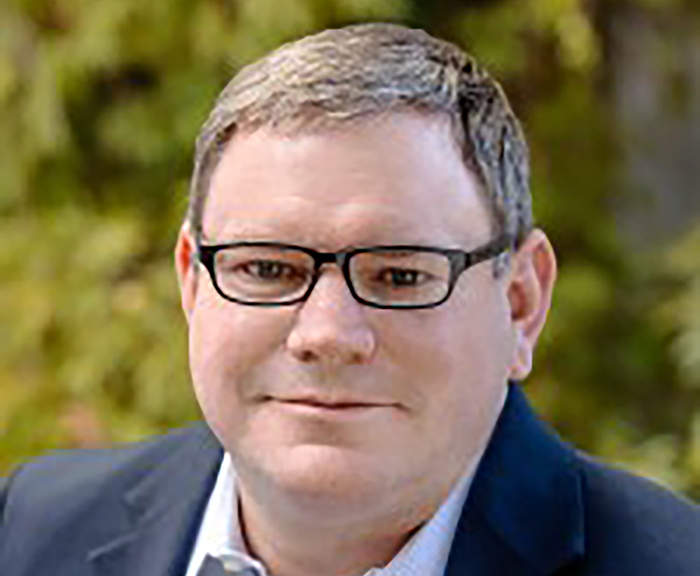 Headshot of Randy Haimovici outside in front of a tree.