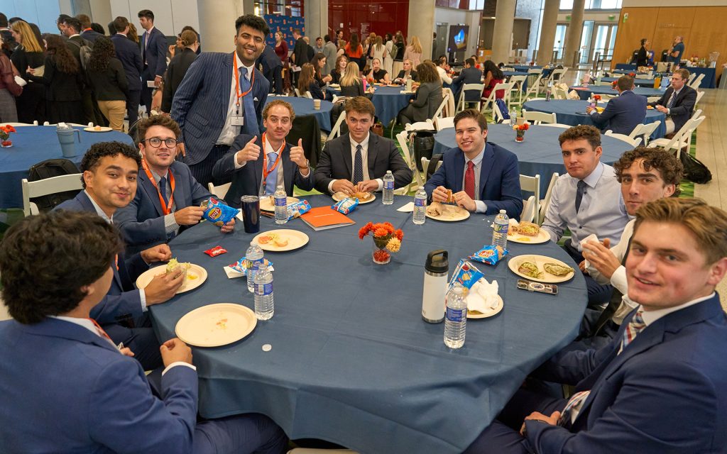 Table of law students share a lunch together in the atrium of Dineen Hall