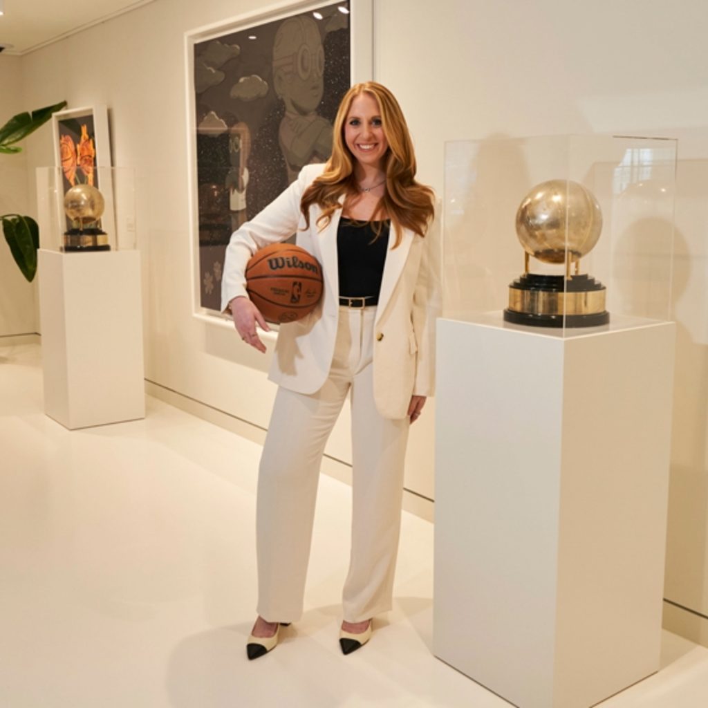 Dana stands next to a trophy holding a basketball