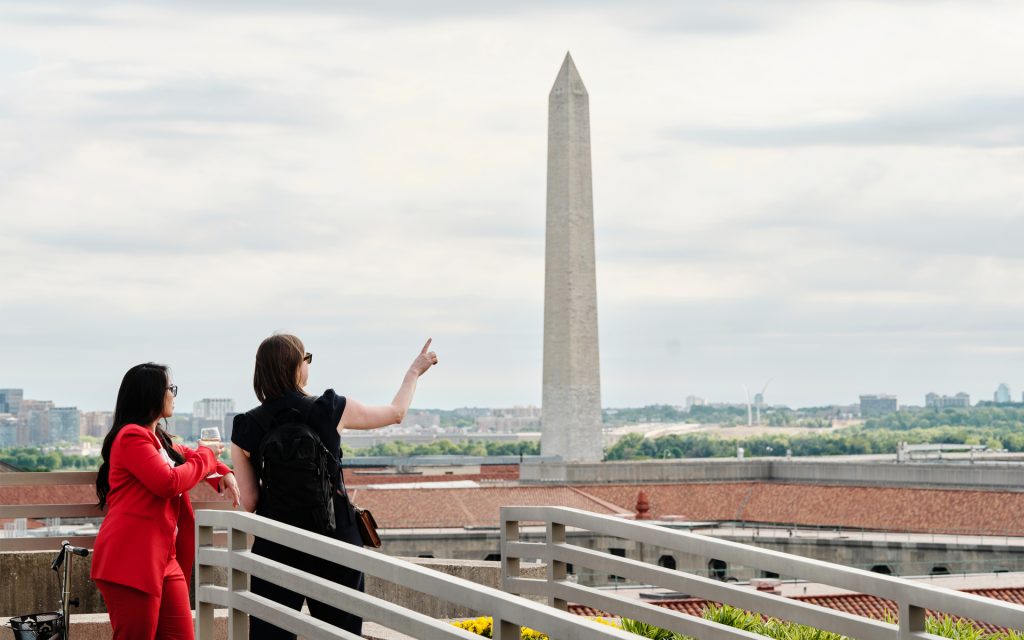 Students point at the Washington monument in the distance