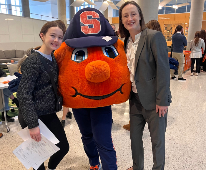 Courtney Abbot Hill L'09 standing with Syracuse University Mascot Otto the Orange and her daughter.